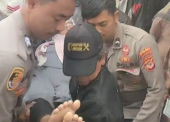 Anggota PAM TPS, Sigap Bantu Warga Yang Pingsan Saat Pencoblosan Pilkades